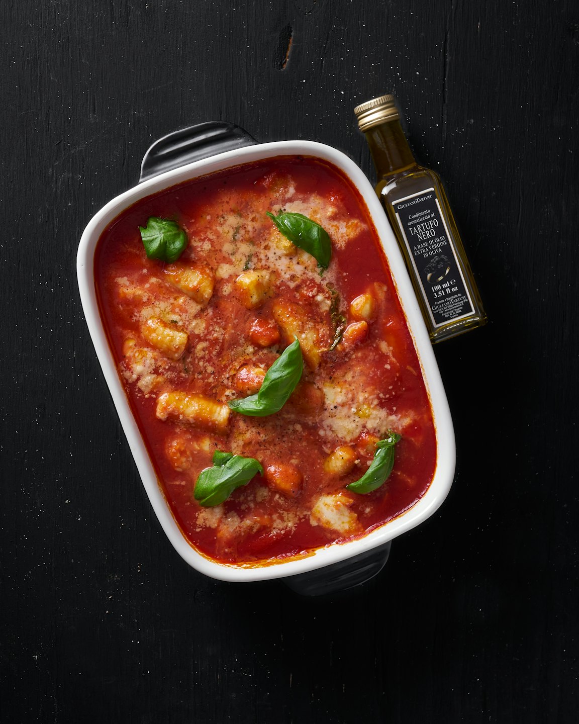Baked gnocchi in tomato sauce with melted cheese and basil.