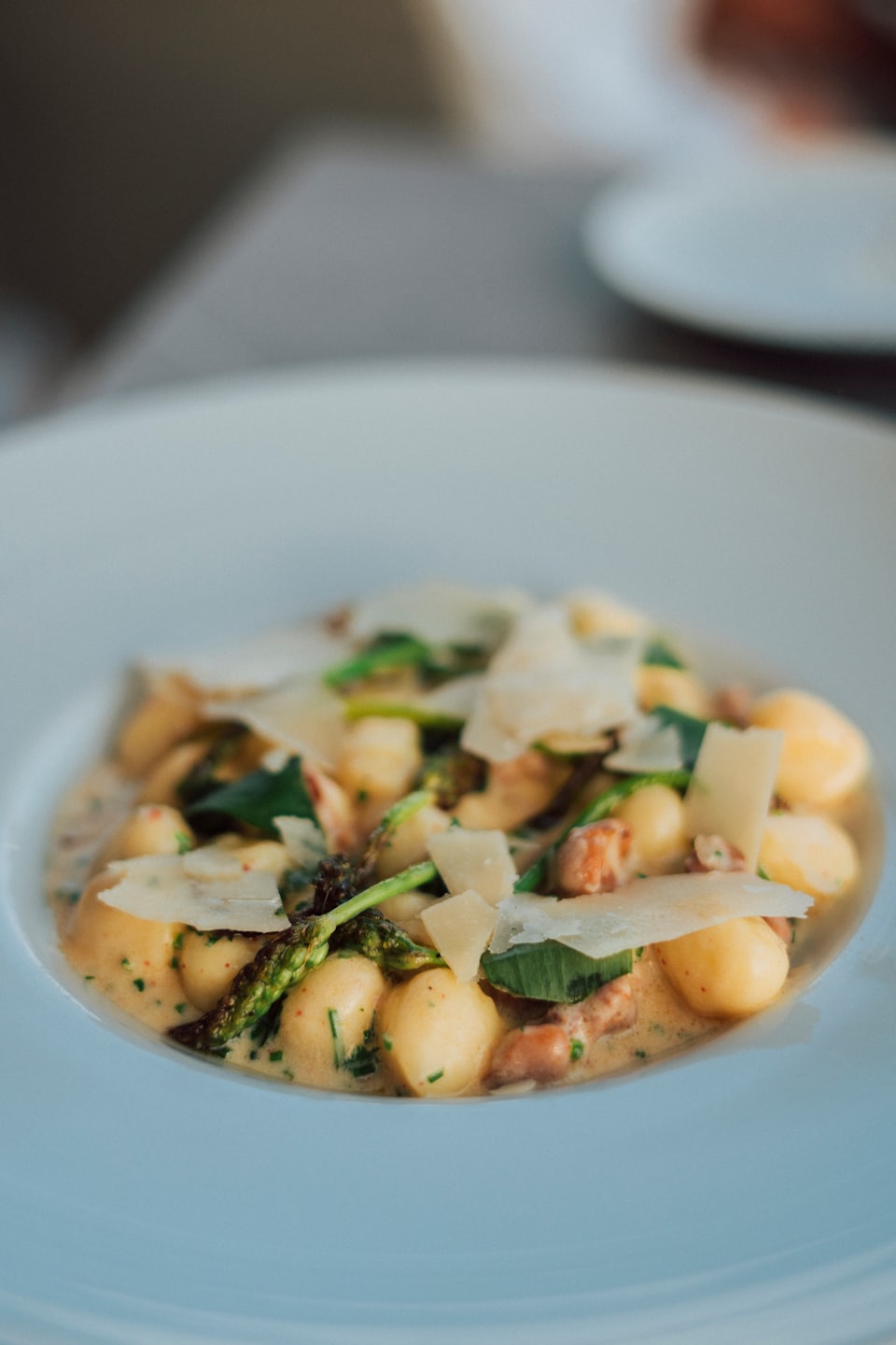 Gnocchi with creamy sauce, parmesan, asparagus, and herbs.